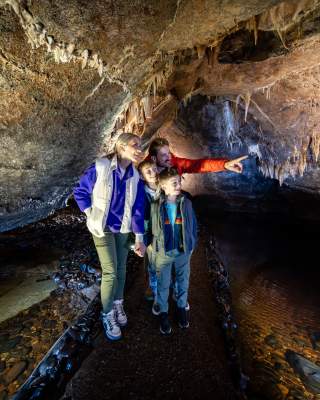 Family enjoying a tour of the underground caves at Marble Arch Caves, looking at stalactites.