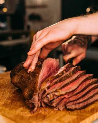 A chef slicing a large piece of beef for Sunday Lunch