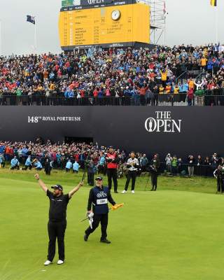 Golfer Shane Lowry celebrating his British Open win on the 18th green in front of a huge crowd