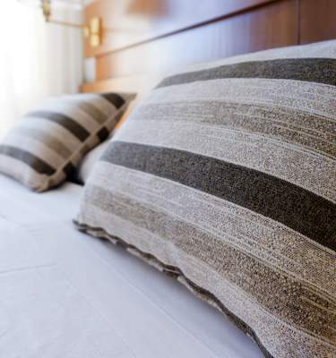 Clean sheets and pillows in a modern hotel room.