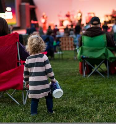 A little girl listens to a concert at Levitt Pavilion