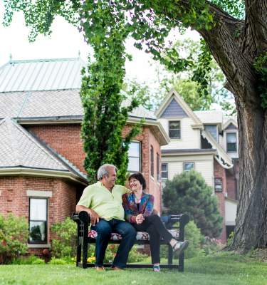 Couple sitting on a bench outside of the Sayre Mansion