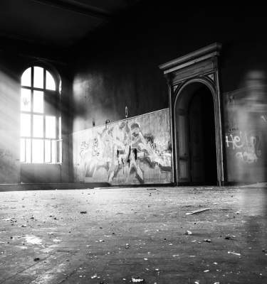 Light streams through windows of a spooky space in a photo by Erik Muller via Unsplash