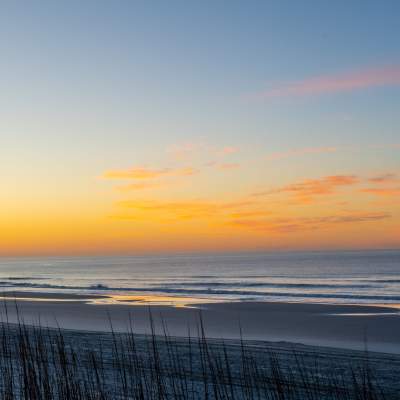An orange sunrise breaks over the horizon