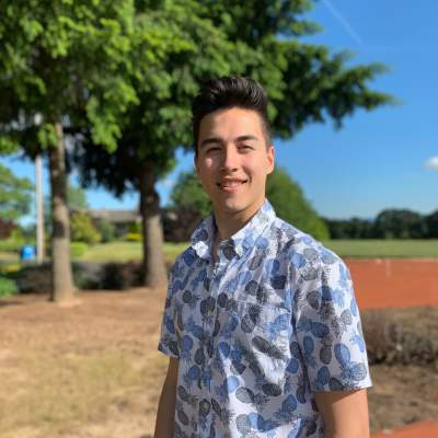 Marketing Intern Ethan Myers standing outside by a tree