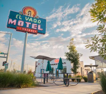 Looking up at the El Vado Motel's neon sign and the site's renovated plaza and office building.