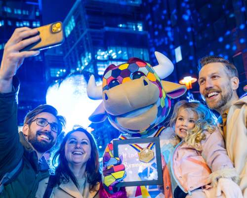 Caroline and family take a photo in front of a Light Festival installation