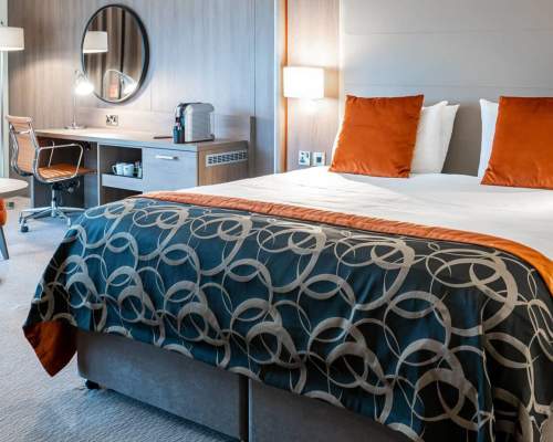 Double bed at Clayon Hotel Birmingham with a dressing table, table and two chairs