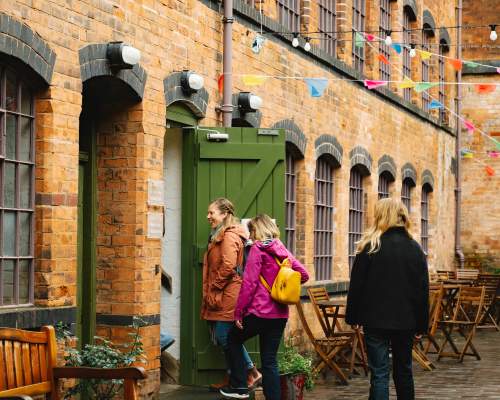 Three women walk into a building.
