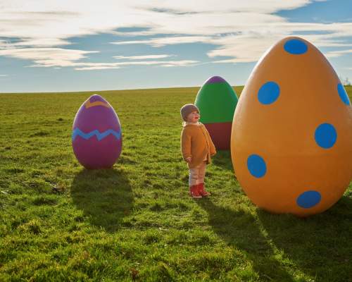 child with giant easter eggs