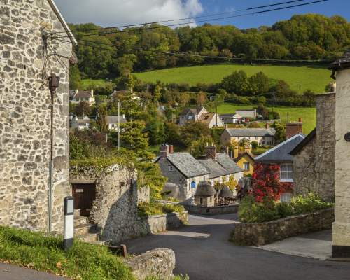 A street in Branscombe surrounded by fields and blue sky