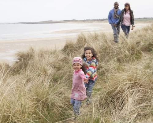 family walking through a sand dune