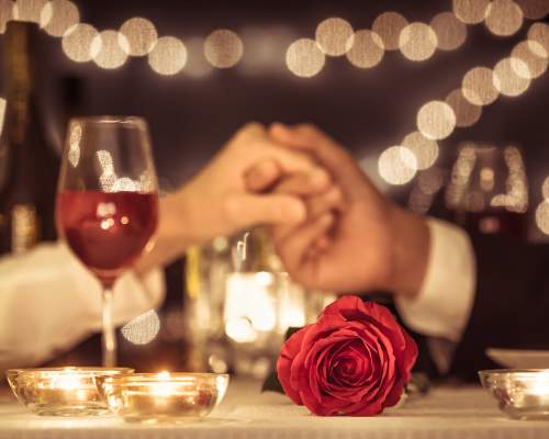 Holding hands over a romantic set table
