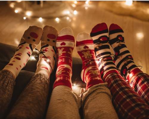 people wearing christmas socks looking cosy