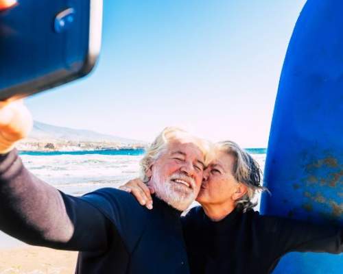 couple taking a selfie with surfboards