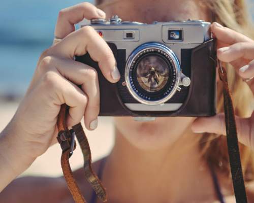 a woman with a camera on the beach