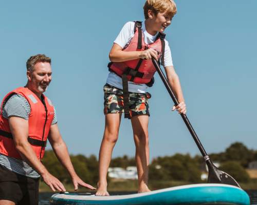 Father helping son to paddle board at Allerthorpe Lakeland Park