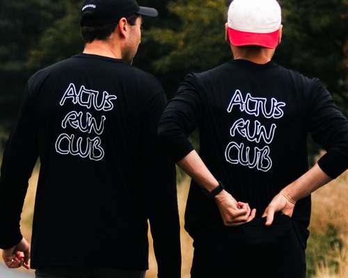 The back of two runners wearing ALTUS run club branded tops in the Yorkshire Wolds.