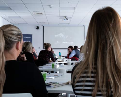 participants of a business workshop, facing the front screen.