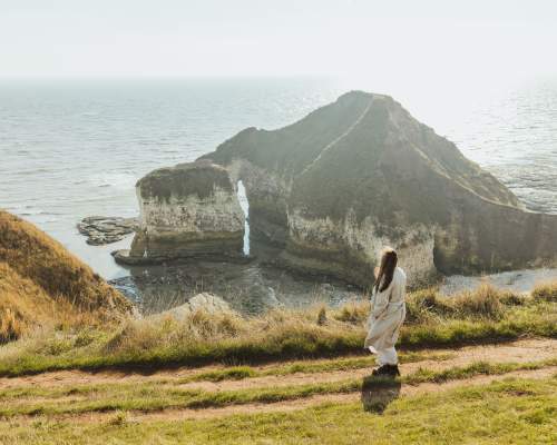 a woman looking out over the drinking dinosaur at Flamborough head