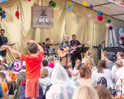 A crowd watching a Taylor Swift tribute act on stage at Den Fest, a summer family festival at William's Den in East Yorkshire.