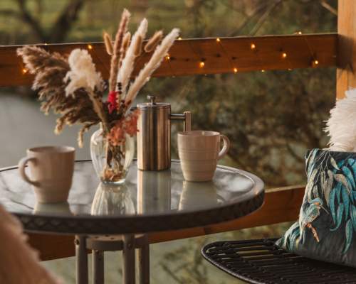 A table and two chairs surrounded by fairy lights, overlooking the water at Kingfisher Lakes in East Yorkshire.