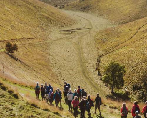 A vast valley in the Yorkshire Wolds with a group of walkers heading towards the bottom