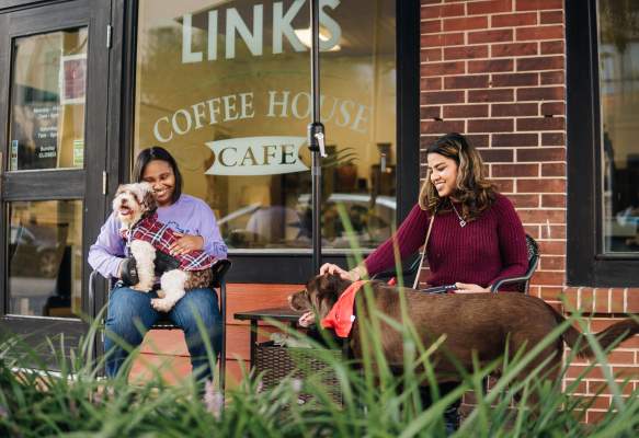 two women with their dogs and coffee