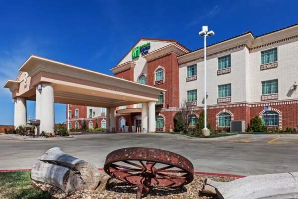 a bright and modern Holiday Inn Express and Suites room in Amarillo with two comfortable beds, clean white linens, and a cozy seating area, offering a relaxed stay with plenty of space to unwind after a day exploring the Texas Panhandle