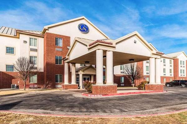 Exterior shot of the entrance of the comfort inn and suites south. White stucco and red brick