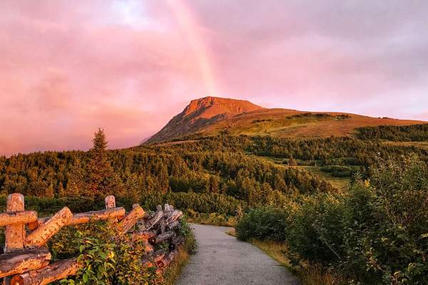 Flattop Mountain shines in the alpenglow with a rainbow in the background. Glen Alps Trailhead at Flattop one of the most accessible trails near Anchorage, Alaska.