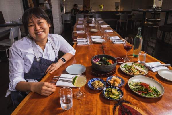 Chef Ji Hye Kim at a table of Korean food