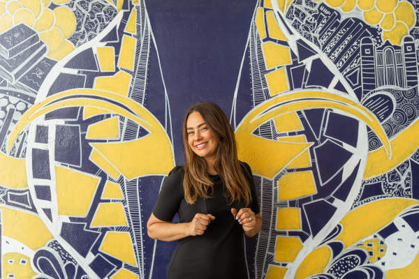 Woman smiling in front of U-M Wings Mural