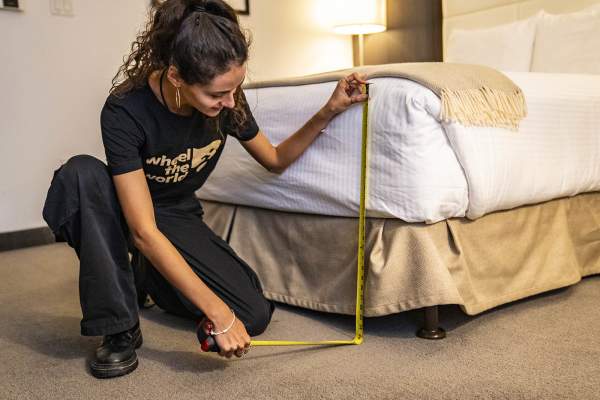 Woman measuring hotel bed for Wheel the World