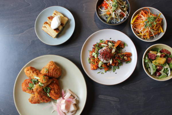 Salads, slaws, fried chicken, and dessert are presented on white plates for Ann Arbor's Restaurant Week