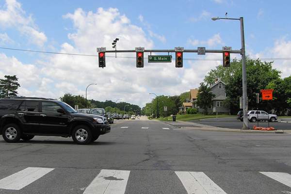 Black car crossing through intersection marked Main Street