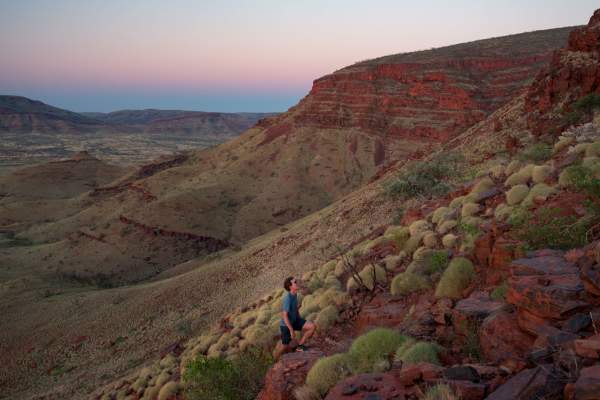 A man climbing up Mt Bruce in Karijini National Park