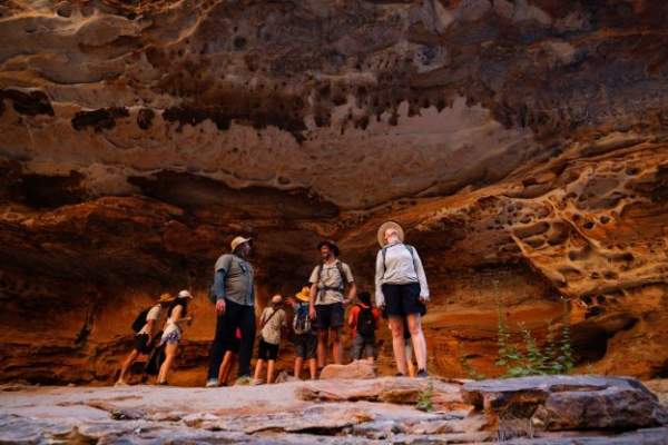 Intrepid-Travel-Australia-WA-Kimberley-Purnululu-National-Park-Bungle-Bungles-Cathedral-Gorge-Walk-group-standing-in-cave-women-looking-up