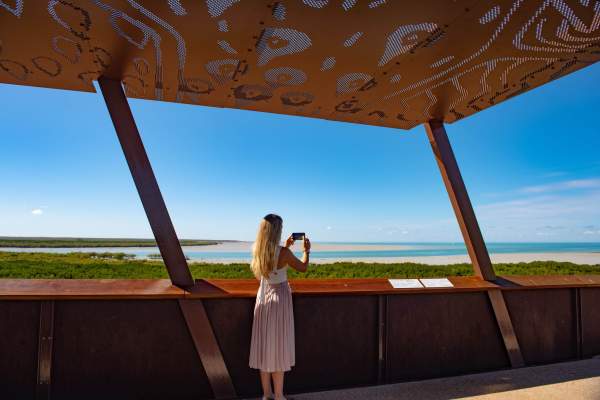 A woman takes a photo at the Roebuck Bay Lookout in Broome's Chinatown area