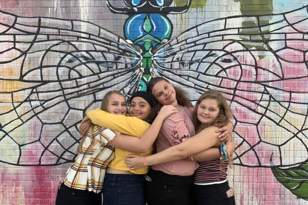 Teens posing in front of Dragonfly wall mural in Beaumont