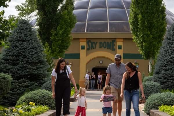 A family with children walking in front of the Reptile Gardens Sky Dome
