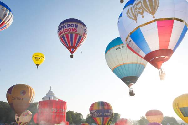 A group of balloons lifting off in a mass ascent at Bristol International Balloon Fiesta - credit Paul Box