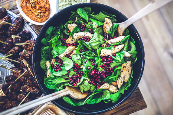 Bowl of Spinach Salad with Chicken and Pomegranate from New Hope Market