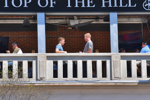 Two people in conversation on the outdoor patio at Top of the Hill Restaurant and Brewery