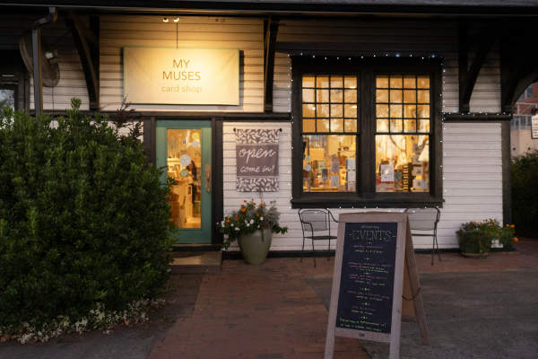 Outside view of My Muses Card Shop at night