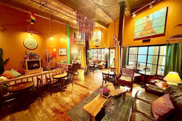 Coffee shop lounge with couches, pillows, tables and chairs.