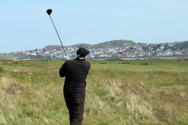 A golfer teeing off at Conwy Golf Club