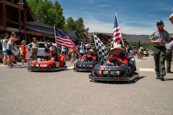 Go Karts with American Flags roll Grand Ave. in a parade