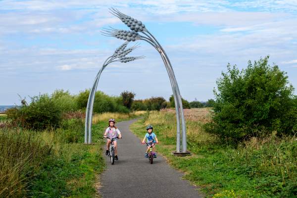 Two children cycling down a rural path