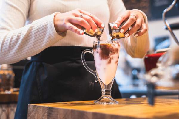 woman pouring chocolate into a glass of milk